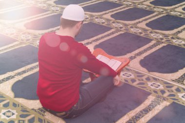 Müslüman adam Kuran 'ı, Kuran' ı, Kuran 'ı, İslam dinini okuyor.