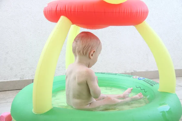 Schöner einjähriger Junge spielt im Schwimmbad — Stockfoto