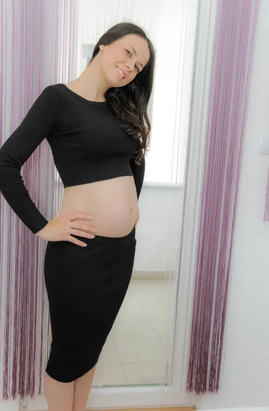 Heureuse femme enceinte avec gros ventre à la fenêtre, grossesse, mère — Photo
