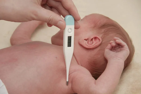 Medición de la temperatura del bebé en el termómetro — Foto de Stock