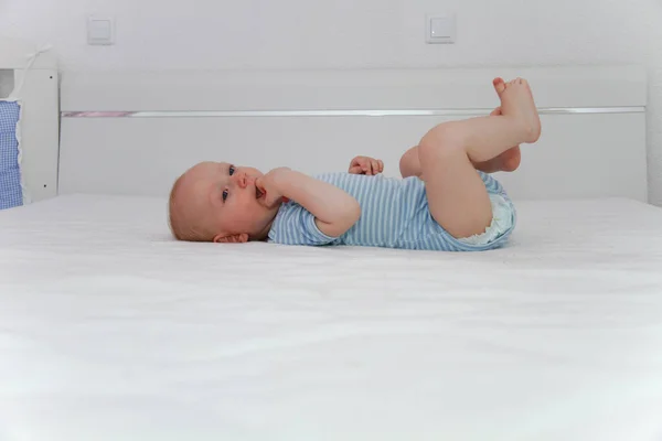 Um ano menino brincando na cama — Fotografia de Stock