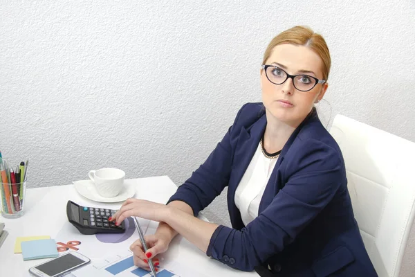 Business woman analyzing investment charts with calculator and l — Stock Photo, Image