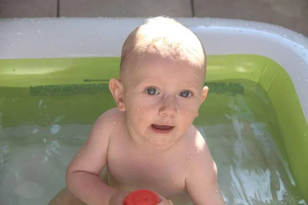 Vacker en ettårig pojke leker i poolen — Stockfoto