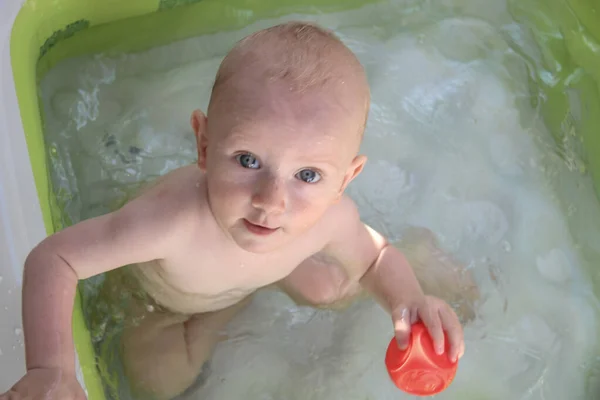 Schöner einjähriger Junge spielt im Schwimmbad — Stockfoto