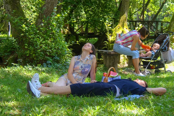 Familia feliz haciendo un picnic en el parque verde — Foto de Stock