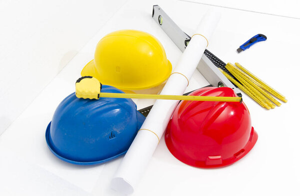 Colorful helmets and tools for construction drawings and buildin