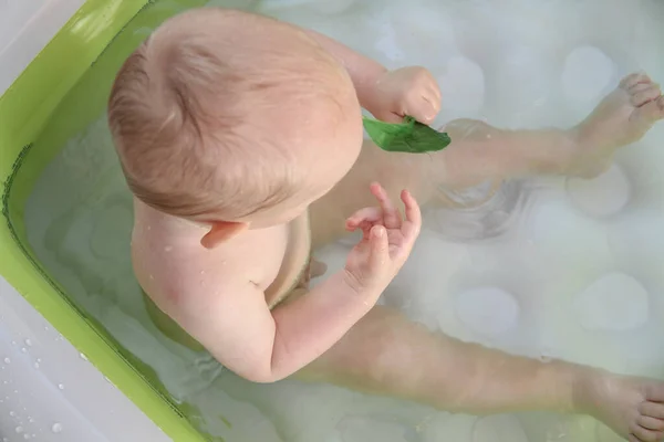 Schöner einjähriger Junge spielt im Schwimmbad — Stockfoto