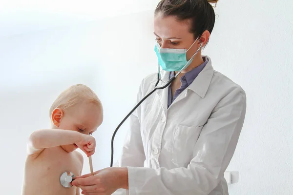 Niño enfermo de un año de edad en la joven doctora —  Fotos de Stock