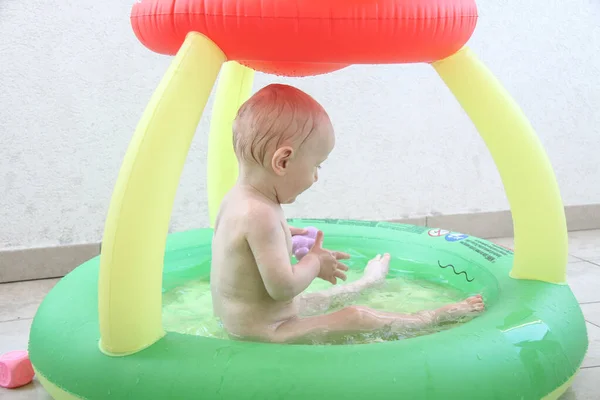 Beautiful one year baby boy playing in the swimming pool — Stock Photo, Image