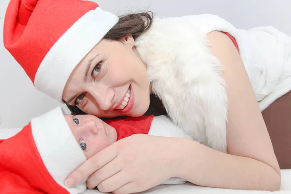 Szczęśliwa matka z mężczyzna dziecko noszenie Boże Narodzenie kapelusze — Zdjęcie stockowe
