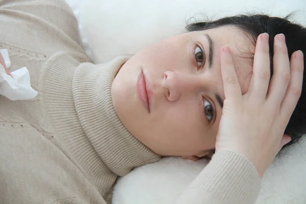 Молодая больная женщина лежит в постели — стоковое фото