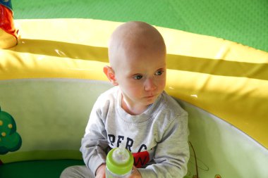 Güzel erkek bebek oyun alanında oynuyor.