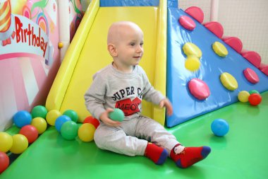 Güzel erkek bebek oyun alanında oynuyor.