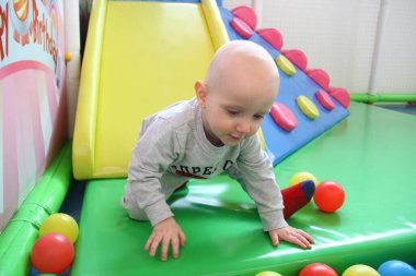 Güzel erkek bebek oyun alanında oynuyor.