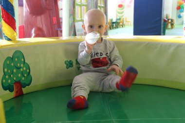 Güzel erkek bebek oyun alanında oynuyor.