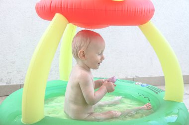 Güzel erkek bebek oyun alanında oynuyor.