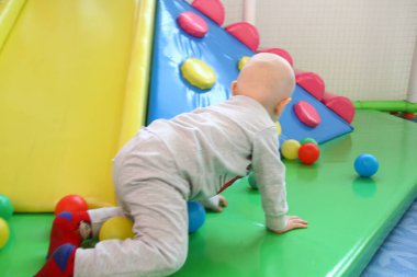 Güzel erkek bebek oyun alanında oynuyor.