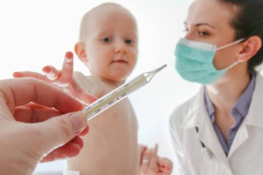 One year old sick baby boy at the young female doctor