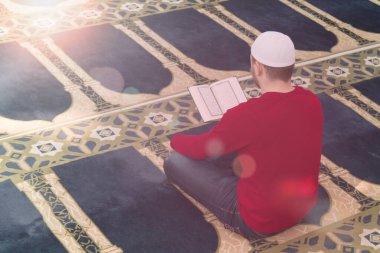 Müslüman adam Kuran 'ı, Kuran' ı, Kuran 'ı, İslam dinini okuyor.