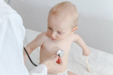 One year old sick baby boy at the young female doctor