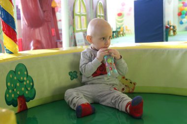 Güzel erkek bebek oyun alanında oynuyor.