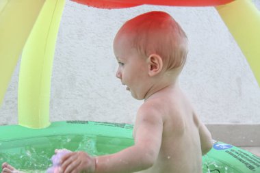 Güzel erkek bebek oyun alanında oynuyor.