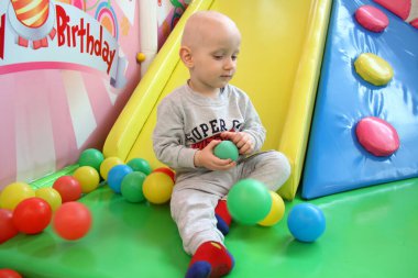 Güzel erkek bebek oyun alanında oynuyor.