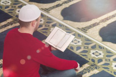 Müslüman adam Kuran 'ı, Kuran' ı, Kuran 'ı, İslam dinini okuyor.