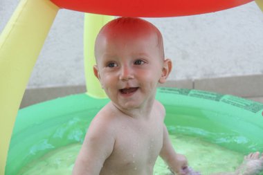 Güzel bir yıl erkek çocuğu yüzme havuzunda oynuyor