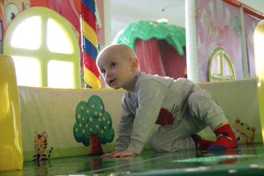 Güzel erkek bebek oyun alanında oynuyor.