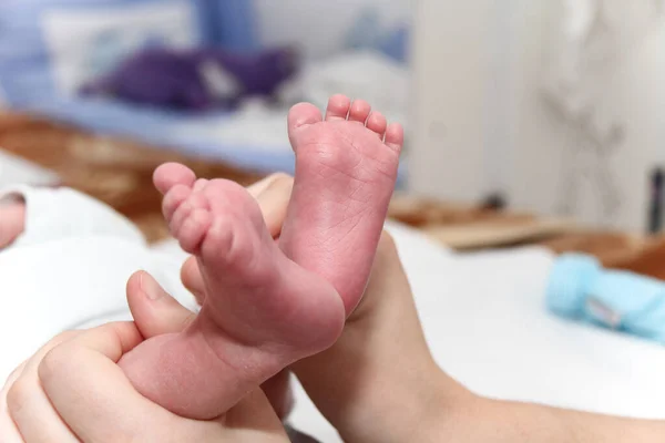 Pied de bébé dans les mains de la mère, nouveau-né petites jambes — Photo