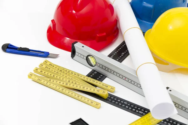 Cascos coloridos y herramientas para los dibujos de construcción y buildin —  Fotos de Stock
