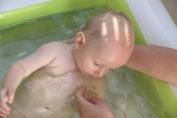 Schöner einjähriger Junge spielt im Schwimmbad — Stockfoto
