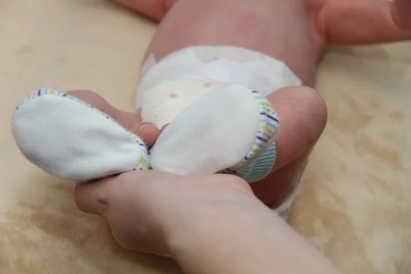 Baby's mond in handen van de moeder, pasgeboren baby beetje benen — Stockfoto