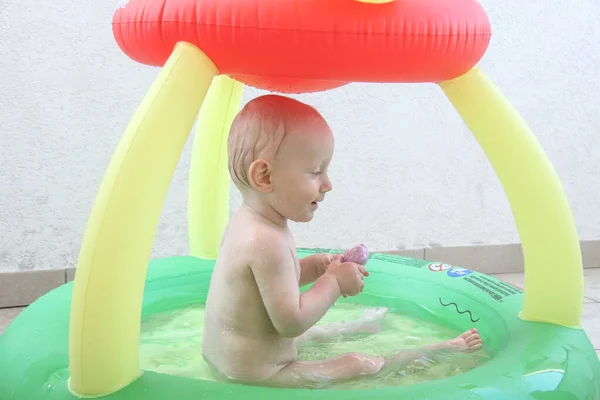 Beautiful one year baby boy playing in the swimming pool — Stock Photo, Image