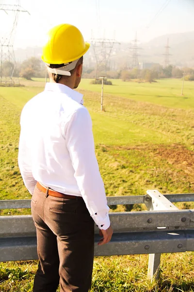 Ingeniero masculino parado en la estación de electricidad — Foto de Stock