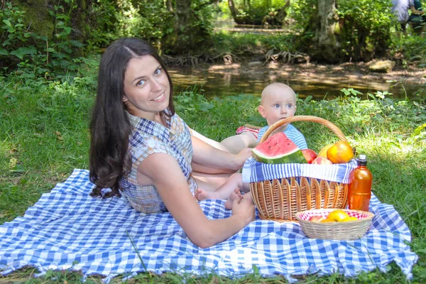 Счастливая мать наслаждается с маленьким сыном и пикником в т — стоковое фото
