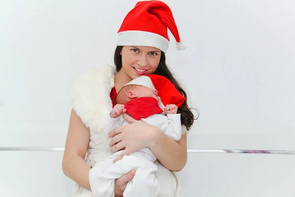 Gelukkig moeder met mannelijke baby dragen kerst hoeden — Stockfoto