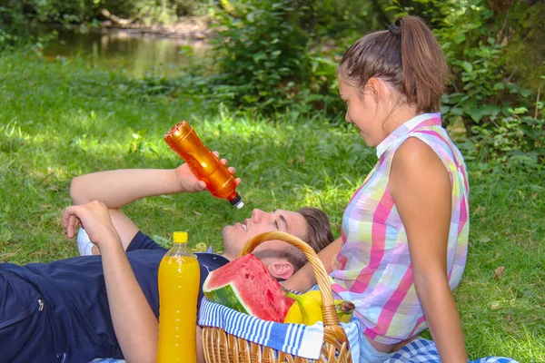 Młoda para urządza piknik w zielonym parku — Zdjęcie stockowe