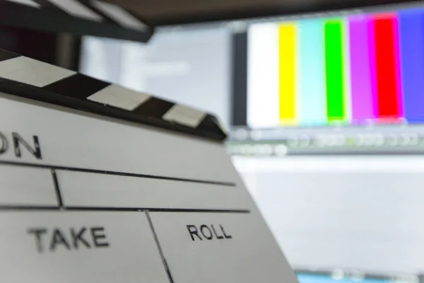 Movie clapper and editing room in background — Stock Photo, Image