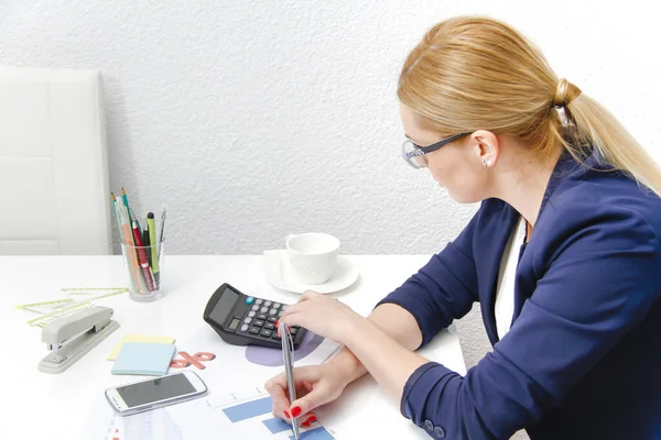 Mujer de negocios analizando gráficos de inversión con calculadora y l —  Fotos de Stock