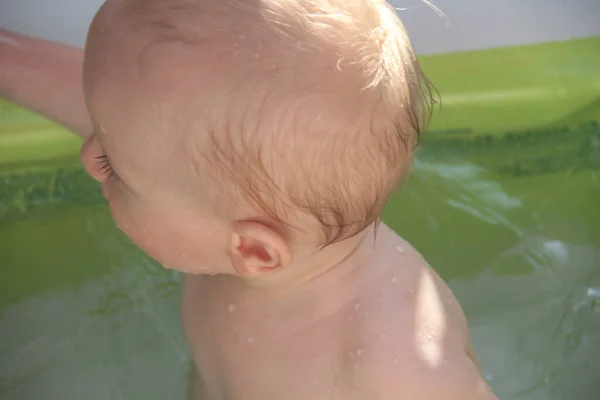 Schöner einjähriger Junge spielt im Schwimmbad — Stockfoto