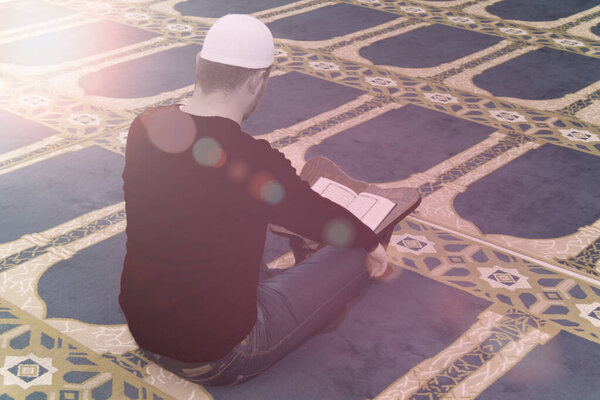 Muslim man reciting from holy book Koran, Qoran, islamic religio