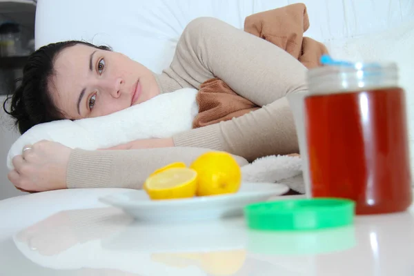 Młoda chora kobieta leżąca w łóżku — Zdjęcie stockowe