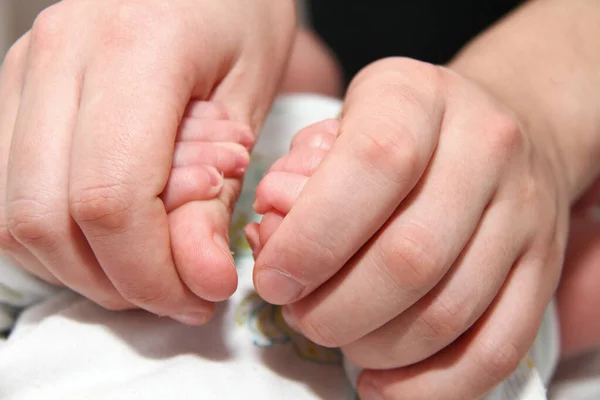 Bébé main tenant le doigt de la mère, nouveau-né bébé — Photo