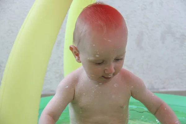 Hermoso niño de un año jugando en la piscina — Foto de Stock