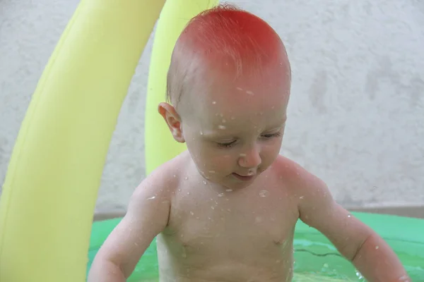 Bonito menino de um ano brincando na piscina — Fotografia de Stock