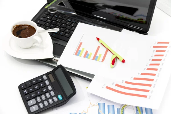 Analyzing business investment charts with calculator and laptop Stock Image