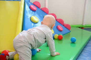 Güzel erkek bebek oyun alanında oynuyor.