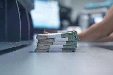 Banka çalışanları banka kasasında para sıralayıp sayıyor.